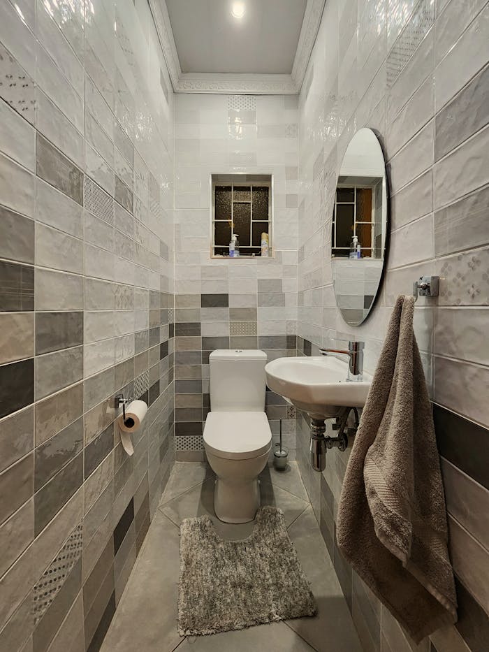 A bathroom with a toilet, sink and mirror